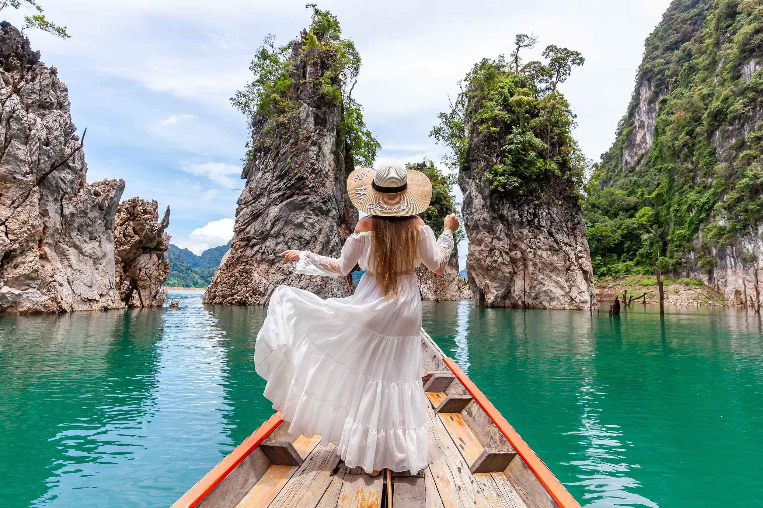Woman On Boat Near Famous Guilin Rocks In Khao Sok National Park In Thailand Woman On Boat Near Famous Guilin Rocks In Khao Sok National Park In Thailand